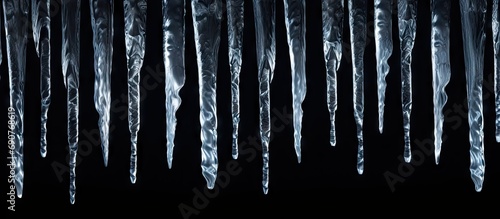 Sharp icicles isolated on black background. Copyspace image. Header for website template photo