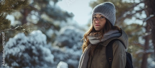 Young woman in warm clothing standing in the forest in winter Troodos mountains Cyprus. Copyspace image. Header for website template photo