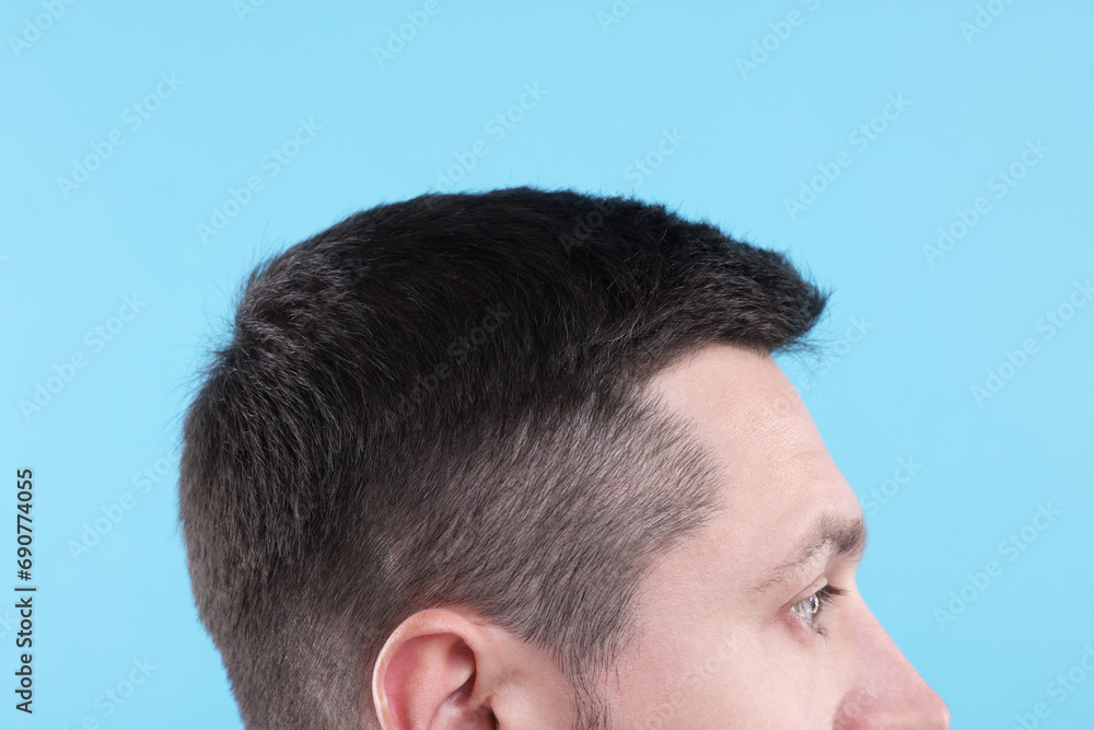 Man with healthy hair on light blue background, closeup Man with healthy hair on light blue background, closeup
