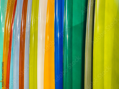 Horizontal coseup of colorful surfboards stacked together in a rainbow of colors. photo