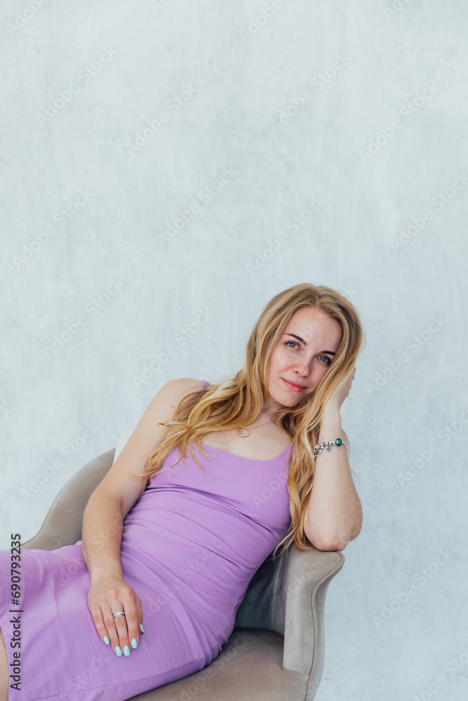 Beautiful blonde woman in summer dress on chair Beautiful blonde woman in summer dress on chair