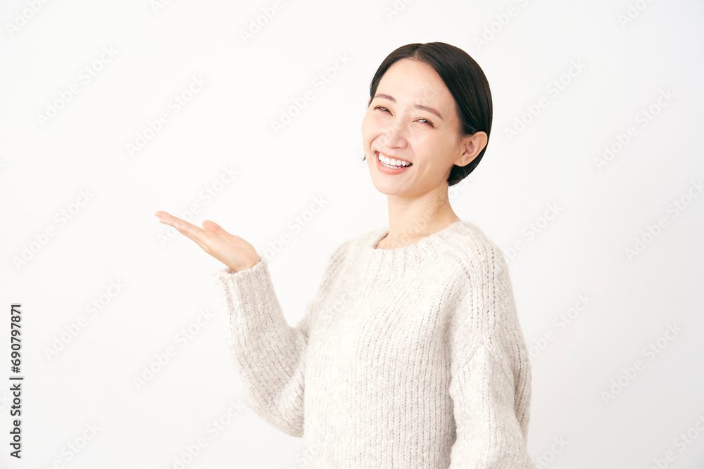 左側を掌で指す中年女性 白背景 左側を掌で指す中年女性 白背景