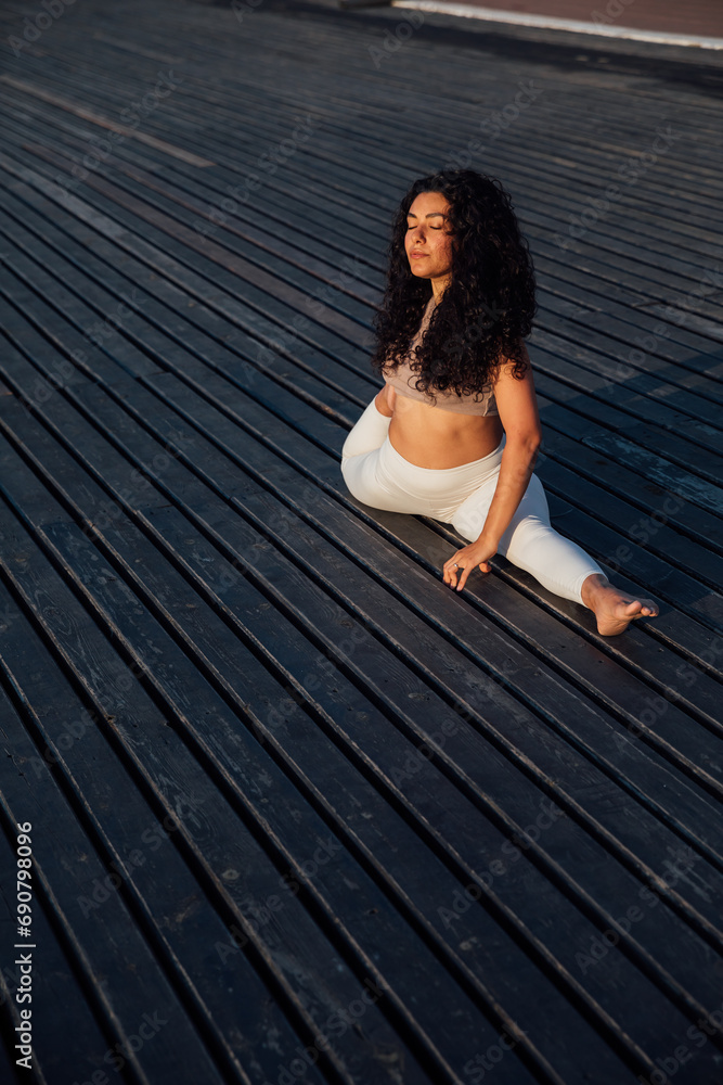 Woman doing yoga asana gymnastics breathing practice stretching