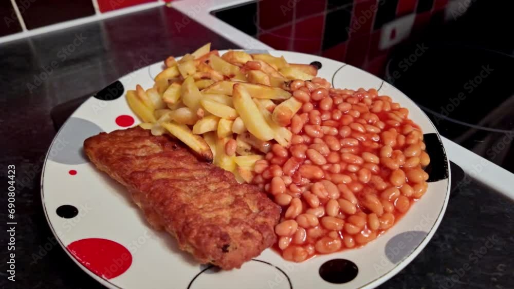 Pull back shot of oven baked fish fillet, oven fries and baked beans on a plate Pull back shot of oven baked fish fillet, oven fries and baked beans on a plate