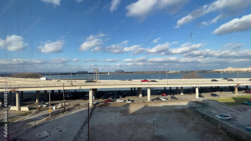 Scarce car traffic on Interstate 64 near Kentucky river in Louisville with bridges on the background during clear winter day with puffy clouds Scarce car traffic on Interstate 64 near Kentucky river in Louisville with bridges on the background during clear winter day with puffy clouds