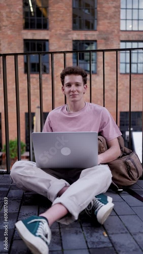 Gen Z student working on laptop after lecture on campus. Young stylish zoomer studiing outdoors. Importance of education of gen Z. photo