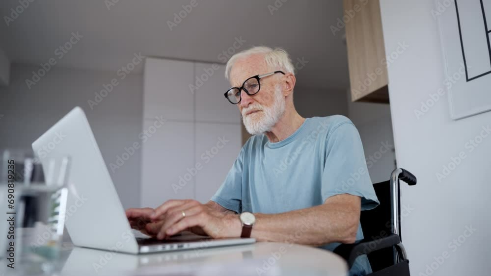 Senior man in a wheelchair working during retirement. Senior man in a wheelchair working during retirement.