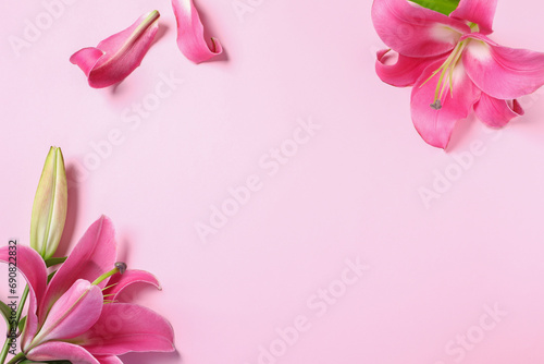 Beautiful pink lily flowers on color background, flat lay. Space for text