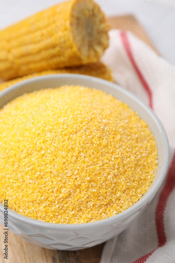 Raw cornmeal in bowl on table, closeup Raw cornmeal in bowl on table, closeup