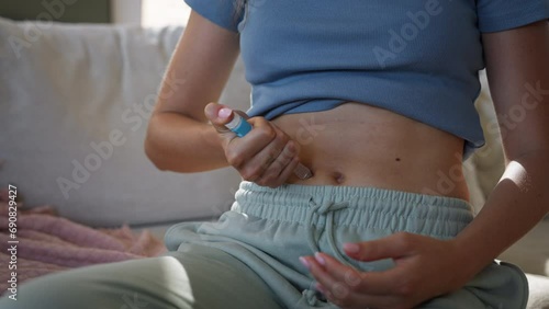 Close-up shot of a diabetic woman injecting insulin into her abdomen. photo