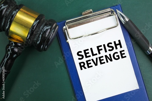 judge's gavel, pen and paper board with the word selfish revenge. the concept of revenge photo