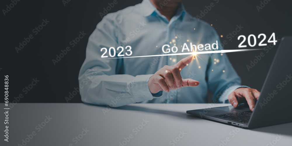 The businessman points to go ahead, signaling a confident stride into the year 2024, anticipating business success and financial growth in the promising future that lies ahead.