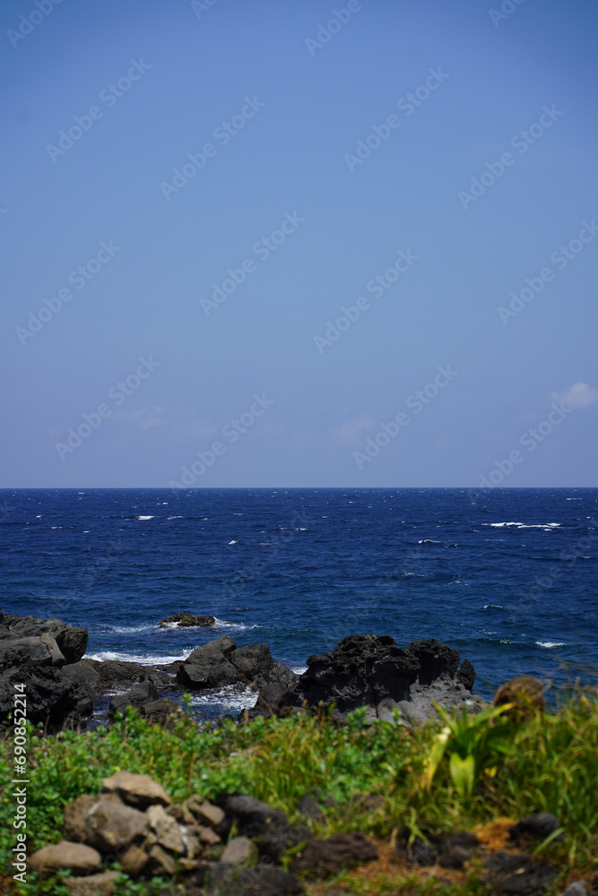 Fresh grasses and black rocks,
After that, there is a blue and wide sea.
