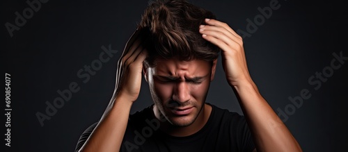 Youthful male experiences head pain.