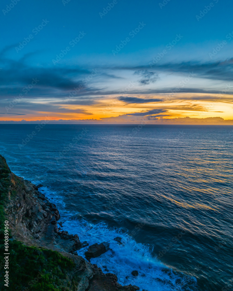 Obraz premium Sunrise over the sea and rock platform with high cloud