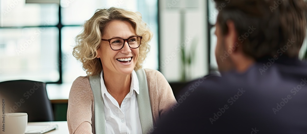 Fototapeta premium Mature woman discussing project with young man in office.