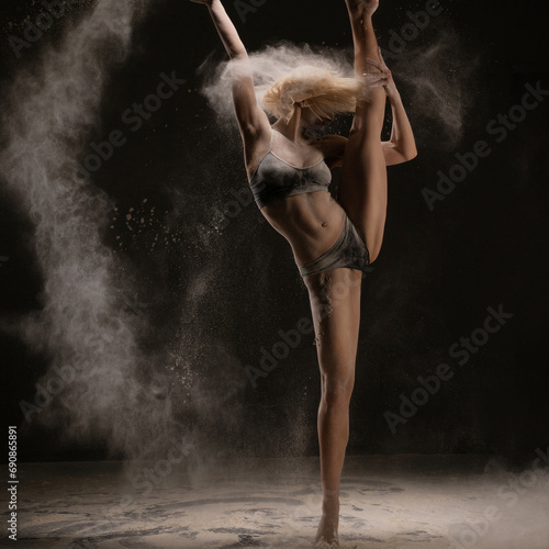 Slim girl dancing in white powder cloud