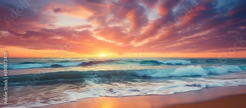 Colorful sky and clouds at sunset over sandy beach and ocean waves in Algarve  Portugal.