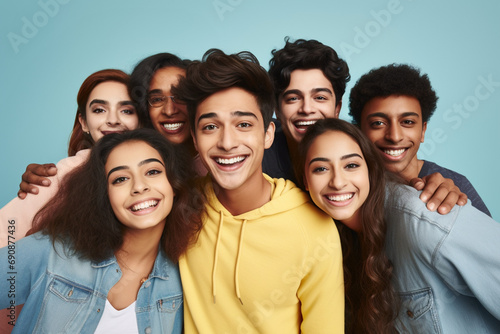 Banner of group of multiracial friends taking selfie picture smiling at camera. Laughing young people celebrating on blue studio background. Portrait of student guys and girls enjoying time together © Valeriia