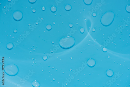water drops on blue background. Bluewater bubbles on the surface ripples. Defocus blurred transparent white-black colored clear calm water surface texture with splash and bubbles. Water waves shining.