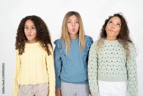 Three beautiful multiracial kid girls  making fish face with lips  crazy and comical gesture. Funny expression.