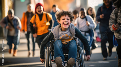 a smiling boy in a wheelchair runs with students in a group photo