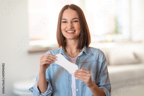 Happy young woman holds daily cotton pad posing at home photo