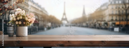 Beautiful blooms in rustic pots on a table with a sunny Paris street in soft focus, banner, design template, travel and lifestyle #690941048