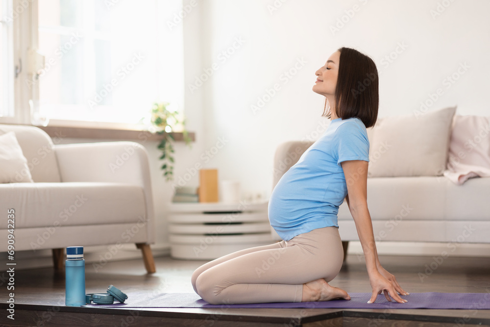 pregnant woman doing backbend during yoga workout at home pregnant woman doing backbend during yoga workout at home