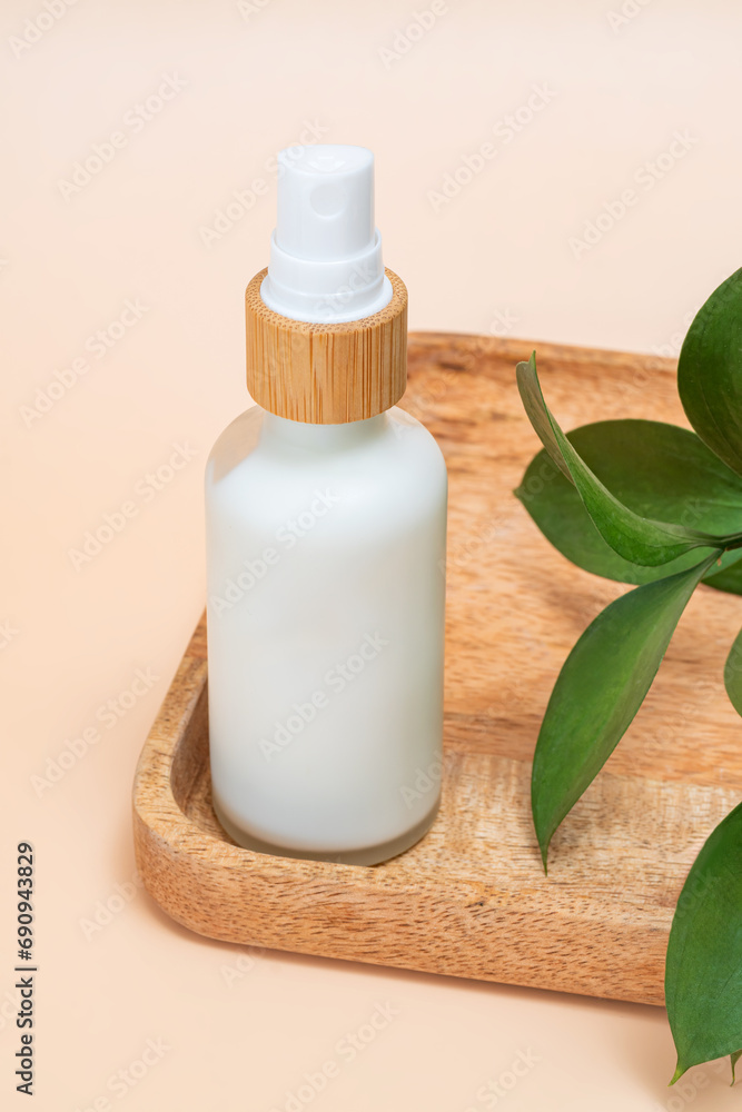 Cosmetic bottle on wooden tray on the light beige background. Background for cosmetic product branding, identity and packaging