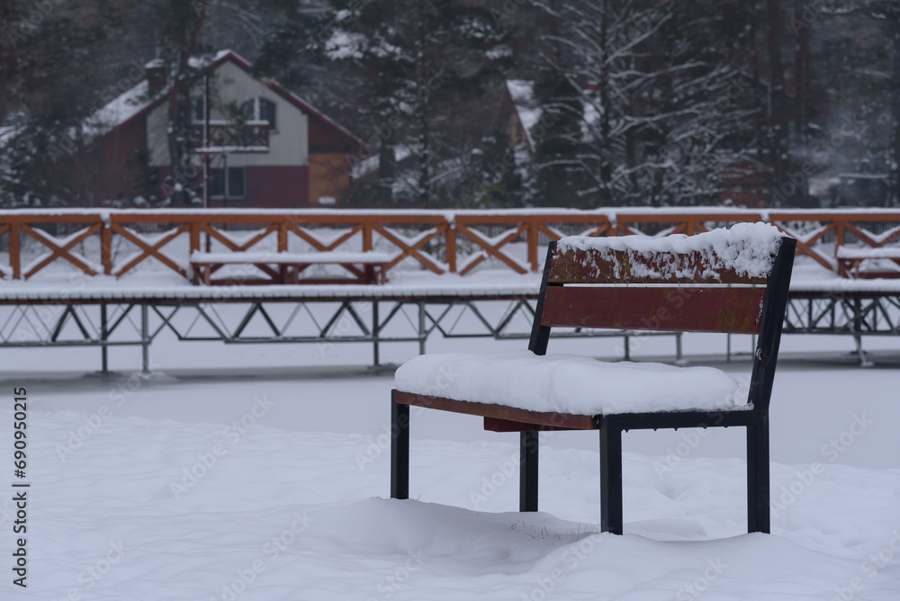 WINTER ATTACK - A bench and a recreational pier by the lake covered with snow
