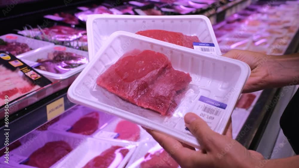 Packaged pieces of raw fresh beef laid out in supermarket refrigerator