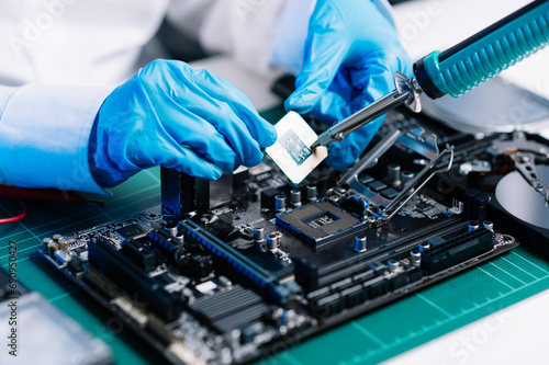 The technician repairing the motherboard in the lab with copy space. the concept of computer hardware, mobile phone, electronic, repairing, upgrade . photo