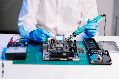 Electronics technician, electronic engineering electronic repair, electronics measuring and testing, repair and maintenance concepts.uses a voltage meter to check and upgrade in shop.