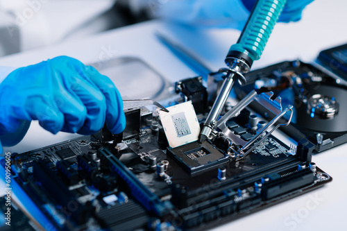 The technician is putting the CPU on the socket of the computer motherboard. electronic engineering electronic repair, electronics measuring and testing, repair.. photo