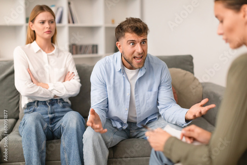 Aggressive husband shouts in anger during tense therapy session indoor