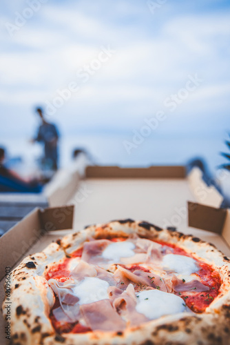 Fototapeta Naklejka Na Ścianę i Meble -  Italian Pizza Margherita with parma ham and mozzarella cheese in box at beach club Thailand
