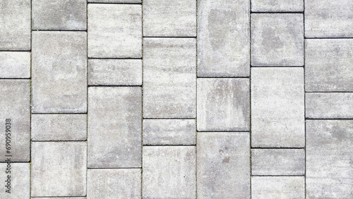  High-definition close-up of a grey stone paved road texture.
