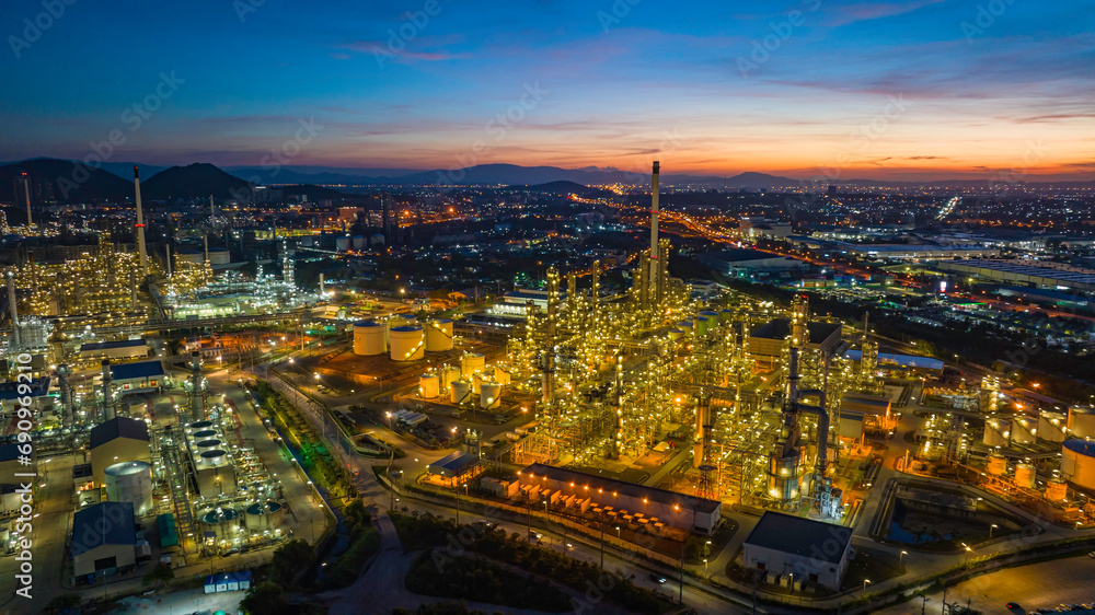 Fototapeta premium Aerial view of the morning of the oil refinery from the drone of the tower of the Petrochemistry industry in the oil and gas industry with cloud sun orange