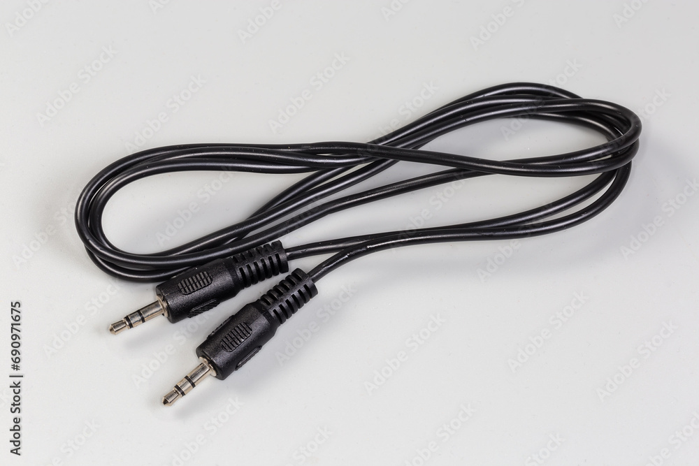 Analog audio cable with mini stereo connectors on gray surface Analog audio cable with mini stereo connectors on gray surface