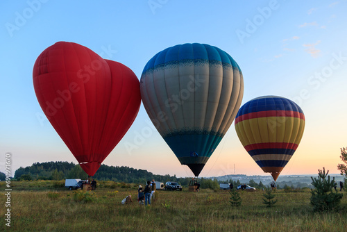 A group of men prepare a hot air balloon for flight  #690971670