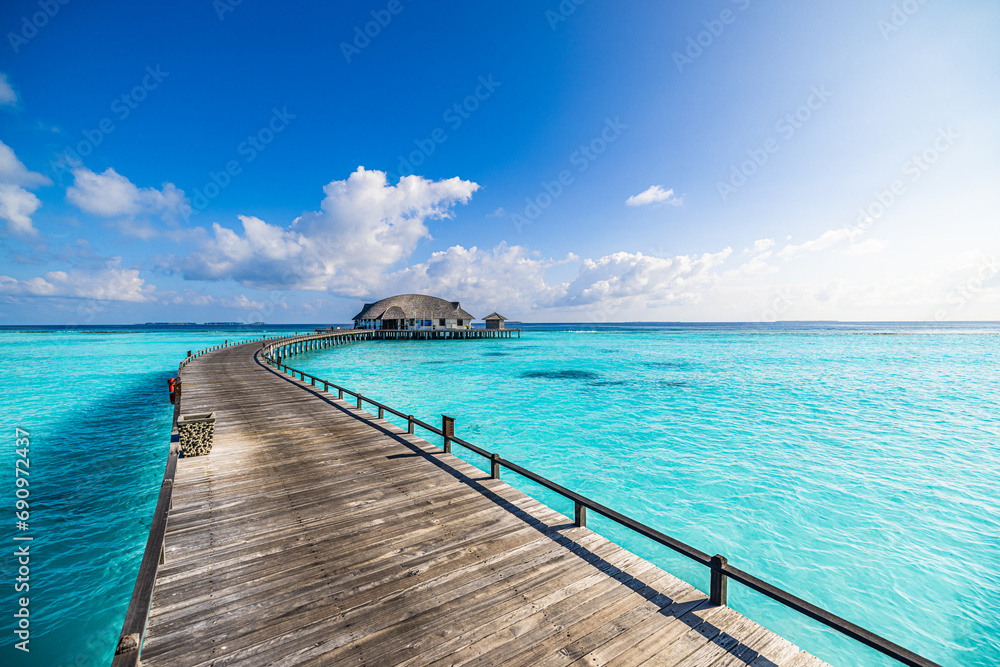 Best travel landscape. Exotic sunny island sea bay wooden pier and water villa over pristine lagoon leads into beautiful tropical paradise. Calm water, sunshine. Amazing vacation, luxury resort