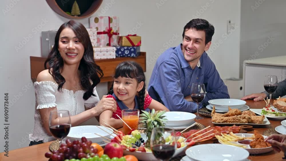Big family with multi-generational making selfie video call via mobile phone to relatives while christmas party over at home. Group of kinfolk various ages celebrating on holiday party in dining room. Big family with multi-generational making selfie video call via mobile phone to relatives while christmas party over at home. Group of kinfolk various ages celebrating on holiday party in dining room.