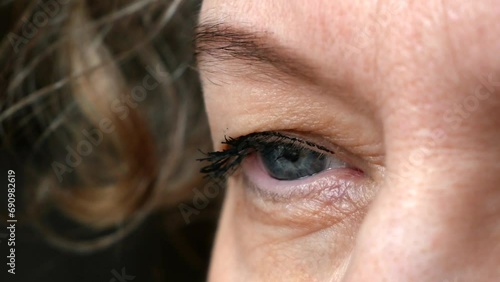 middle aged female's eye with drooping eyelid making eyebrow makeup. Ptosis is a drooping of the upper eyelid, lazy eye. Cosmetology and facial concept, first wrinkles photo