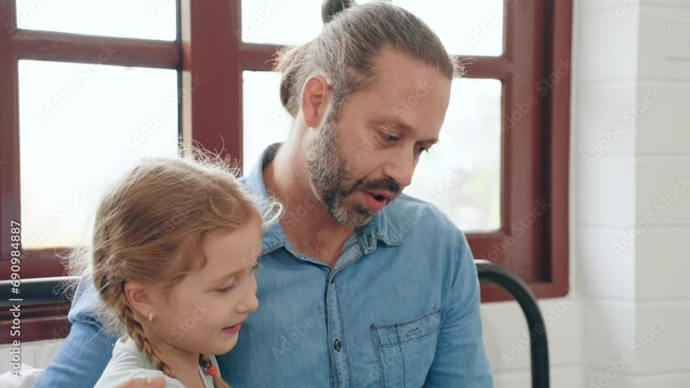 Young father working at home on computer laptop on bed while cute little daughter walking to hug with love. Relationship family concept Young father working at home on computer laptop on bed while cute little daughter walking to hug with love. Relationship family concept