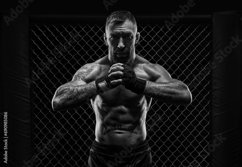 The dramatic black white image of the MMA fighter. Photography in a real octagon. Brutal fighter photo