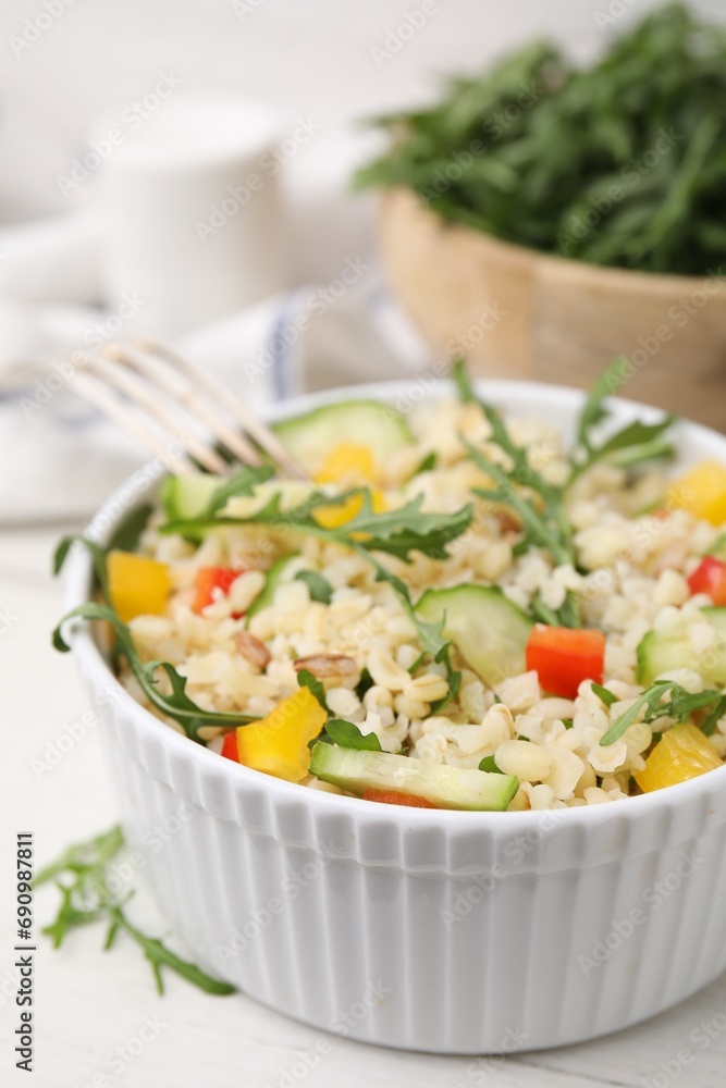 Cooked bulgur with vegetables in bowl on white wooden table, closeup Cooked bulgur with vegetables in bowl on white wooden table, closeup