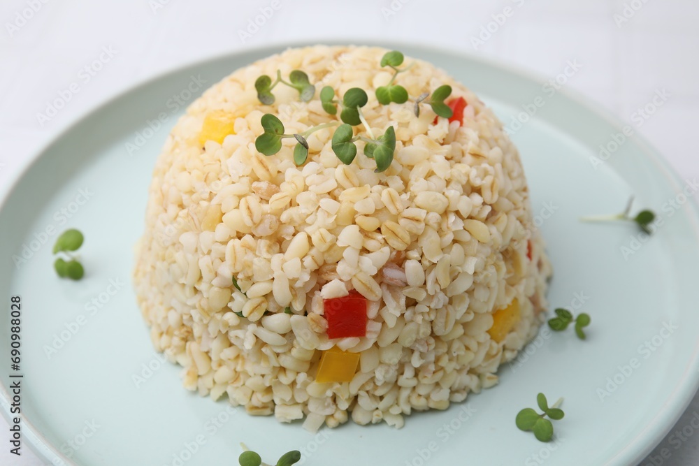 Delicious bulgur with vegetables and microgreens on table, closeup Delicious bulgur with vegetables and microgreens on table, closeup