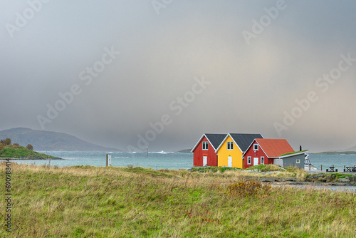 beautiful colored houses on the island Sommarøya, Troms, Norway, surrounded with with salt water from Atlantic ocean, autumnal colored meadows and stones. special place for adventure  photo