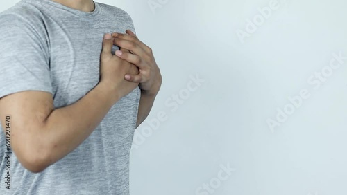asian man pressing chest with painful expression. Severe heartache, having a heart attack or painful cramps, heart disease.